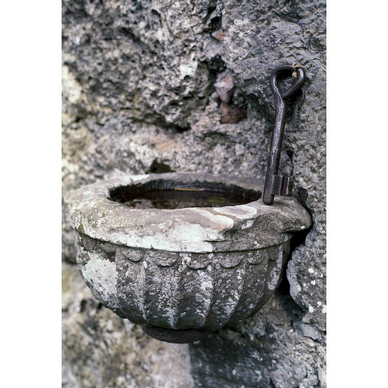 a wall-mounted stoup with the church old key on it