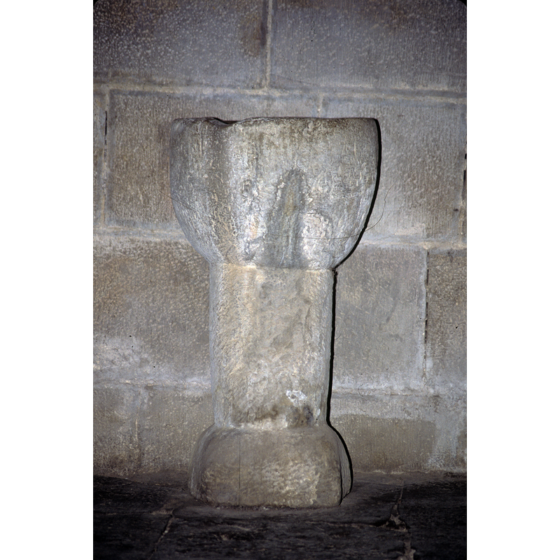 Source caption: "Pila bautismal [...]  Realizada en arenisca. Se articula en un pie cilíndrico que apoya en un basamento de sección cuadrada, una pila de forma acampanada, con la parte inferior plana. Ubicación: Bajo coro Siglo XIV Estilo: Gótico"
