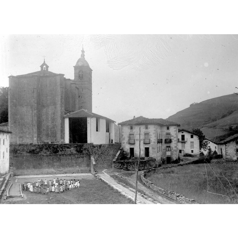 Source caption: "Iglesia de Santa Catalina. En la plaza, niñas en corro. NOTAS: En el negativo, en el reverso, manuscrito, de mano del autor "3. Lizarza" En el positivo, en el reverso, manuscrito, de mano del autor "Lizarza. Iglesia Parroquial y vista parcial. 1915"