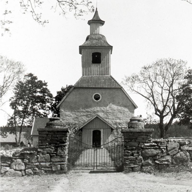 the gate seen from the outside: the basin of the old font rests atop the right pillar, the base on the left