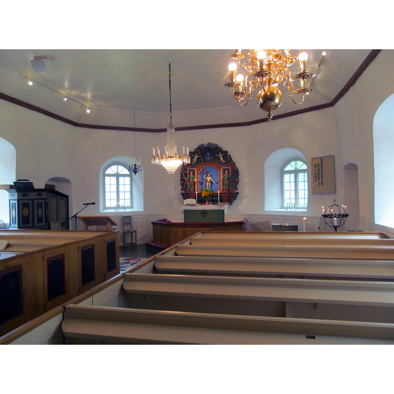 the top of the medieval font is just discernible at the far end, by the right window of the apse