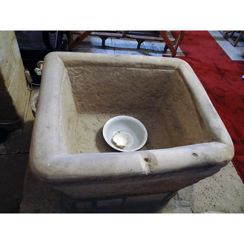 the drilled hole in the upper rim was probably made to hold an anchoring for a font cover -- the baptismal dish may be hiding a central drain hole