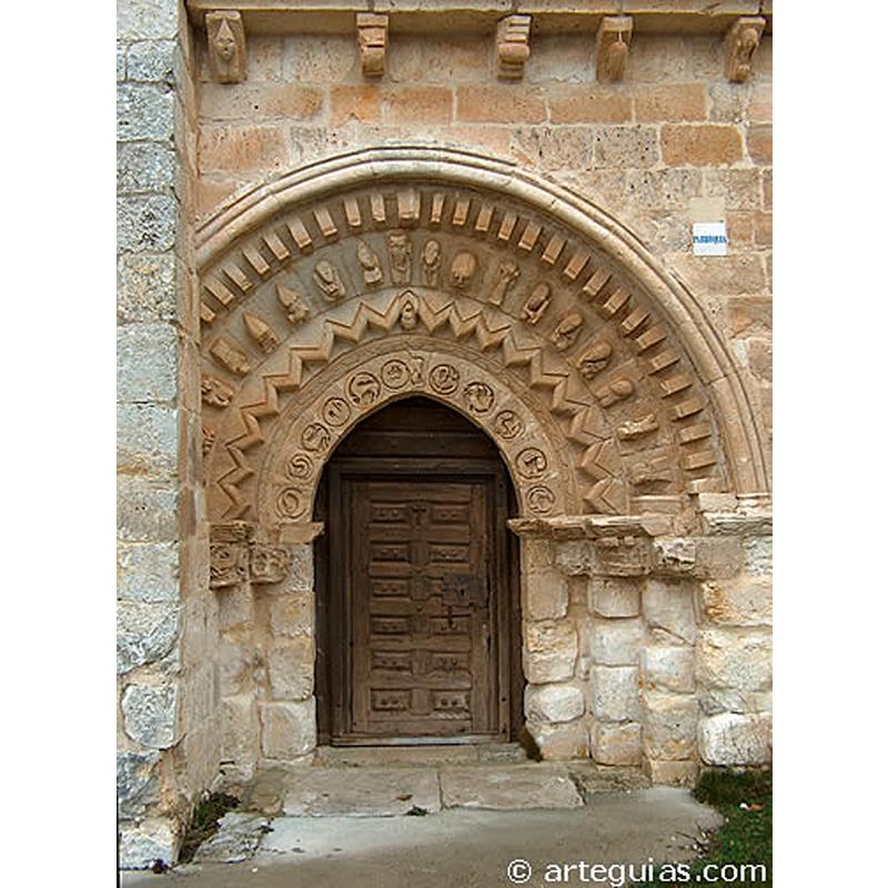 Source caption: "puerta de anchas arquivoltas apuntadas, dos de ellas decoradas con prominente zigzagueado y picos resaltados Son las otras dos restantes las que centran toda nuestra atención. La arquivolta interior tiene once medallones circulares donde se tallaron animales y figuras a bajorrelieve de gran belleza y cuya interpretación se aproxima a la de un zodiaco. La talla es de gran expresividad y sobresalen los escorzos que los animales han de hacer para adaptarse al marco circular en que se inscriben. La tercera arquivolta es también muy expresiva, aunque parece de manos muy distintas pues las figuras que esculpió este artista aparecen en un altorrelieve muy acentuado. Las cabezas de los personajes tiene una característica forma de gota y sus rostro evidencian esquematismo en los rasgos: ojos almendrados saltones, nariz triangular y boca pequeña sólo incisa sin labios. Estos personajes son, en su mayoría, músicos, bailarinas o contorsionistas. Aunque hay un grupo de tres que semejan a un rey, un monje y un anciano." [David de la Garma Ramirez [www.arteguias.com/imagenes4/minondesantibanez.jpg] [accessed 22 July 2020]]