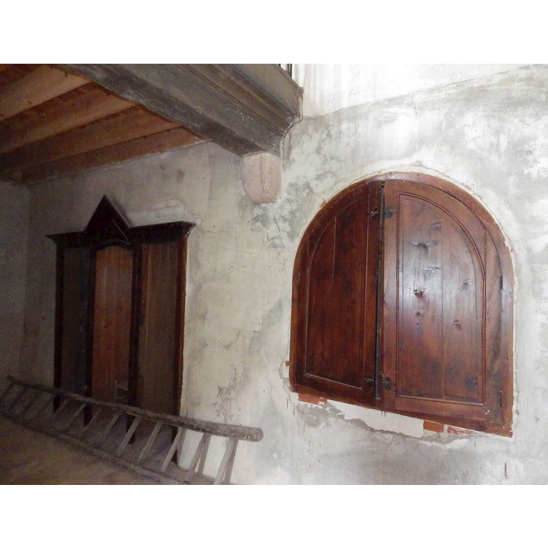showing the west end of the north wall of the nave; the back doors belong to the confessional; the shutters in the foreground hide the embedded baptismal font
