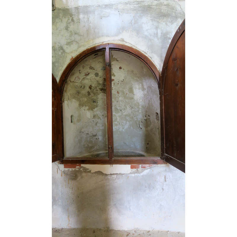 the shutters open into the wall niche where the font is located