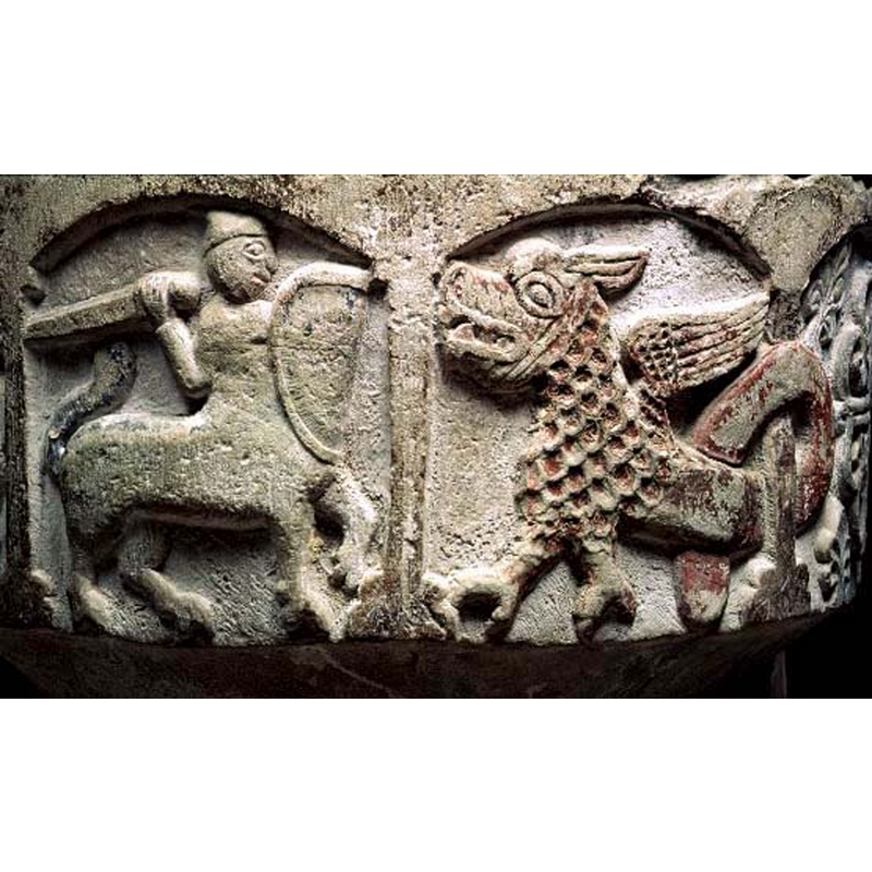the large scaly dragon has its tail wrapped around a column at the back; much reddish paint remains on the dragon's body