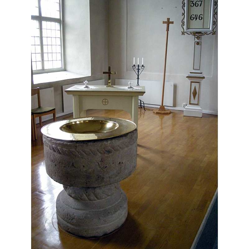 the medieval font at the east end of the nave