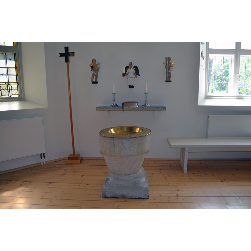 the font at the east end og the nave with the south wall behind