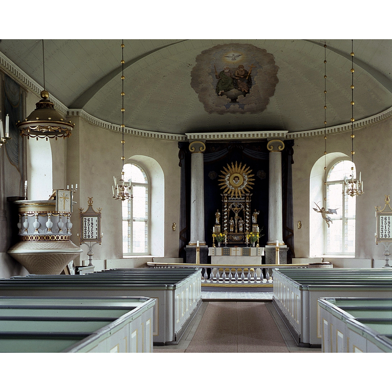 the top of the medieval font is visible on the right, in front of the east bank of pews, by the southeast chancel window