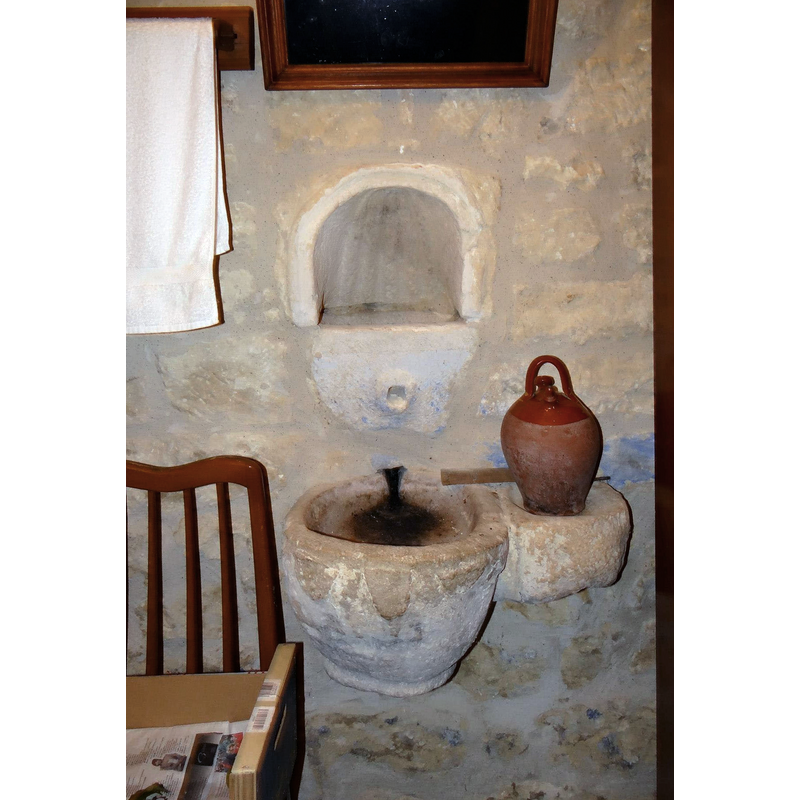 an old stone holy-water stoup is seen here by the lavabo; the stoup may have been wall-mounted in the old church, as the arm extension suggests
