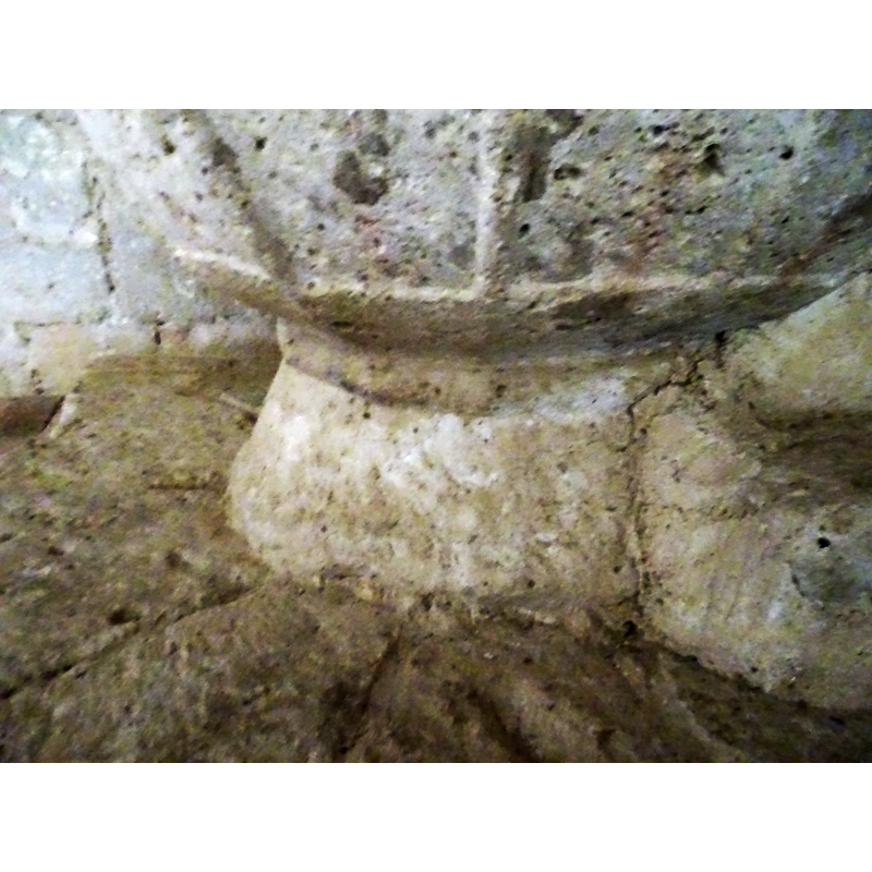 damaged and very worn now; part of the base is cemented to the wall