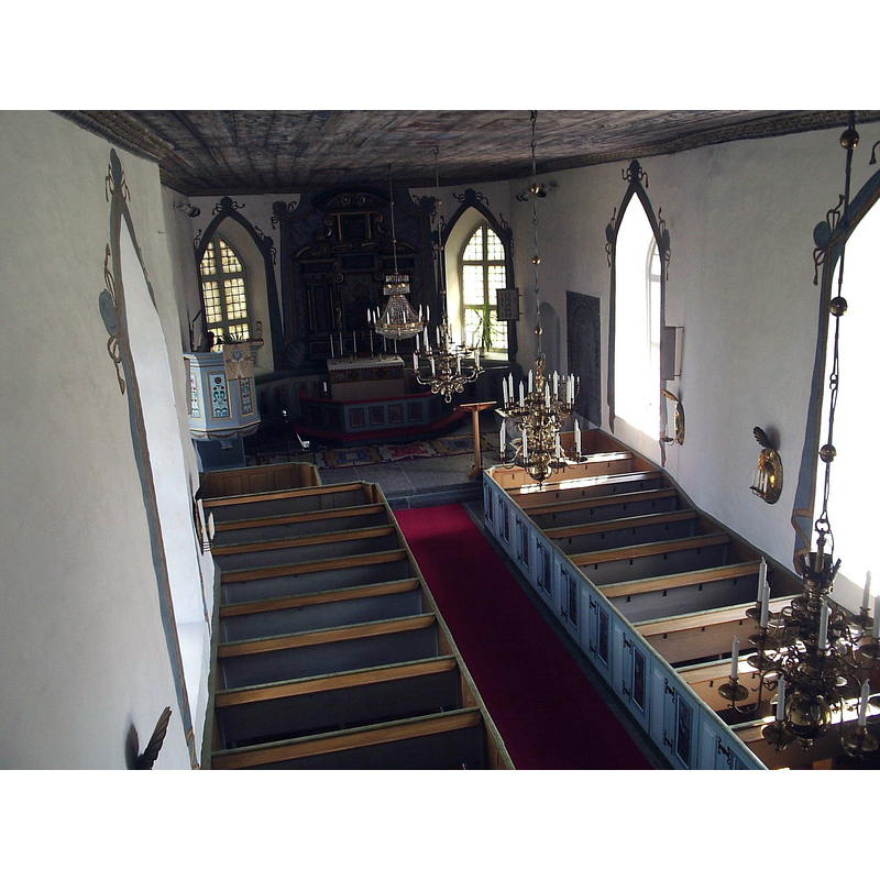 the medieval font is located at the east end, south side, right next to the lectern, but it is practically hidden in this image behind one of the candelabra
