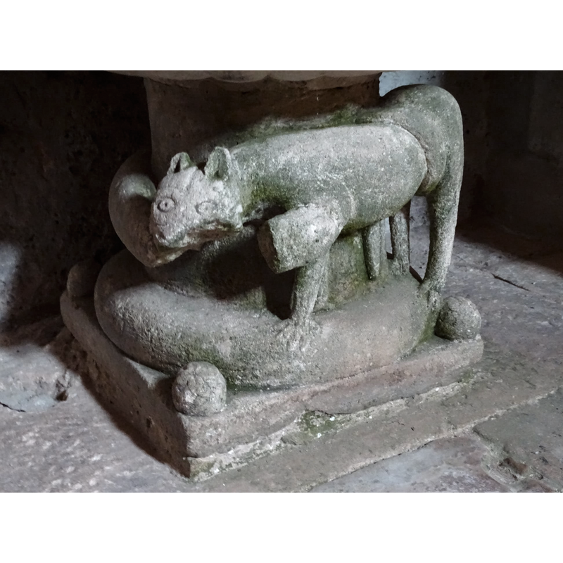 in this photograph the upper body of the snake -minus the missing part- can be discerned: it comes from behind the round stem of the font and is caught at the from in the lion's maw; unfortunately the neck of the snake has broken off and we only have its head biting the shoulder of the lion