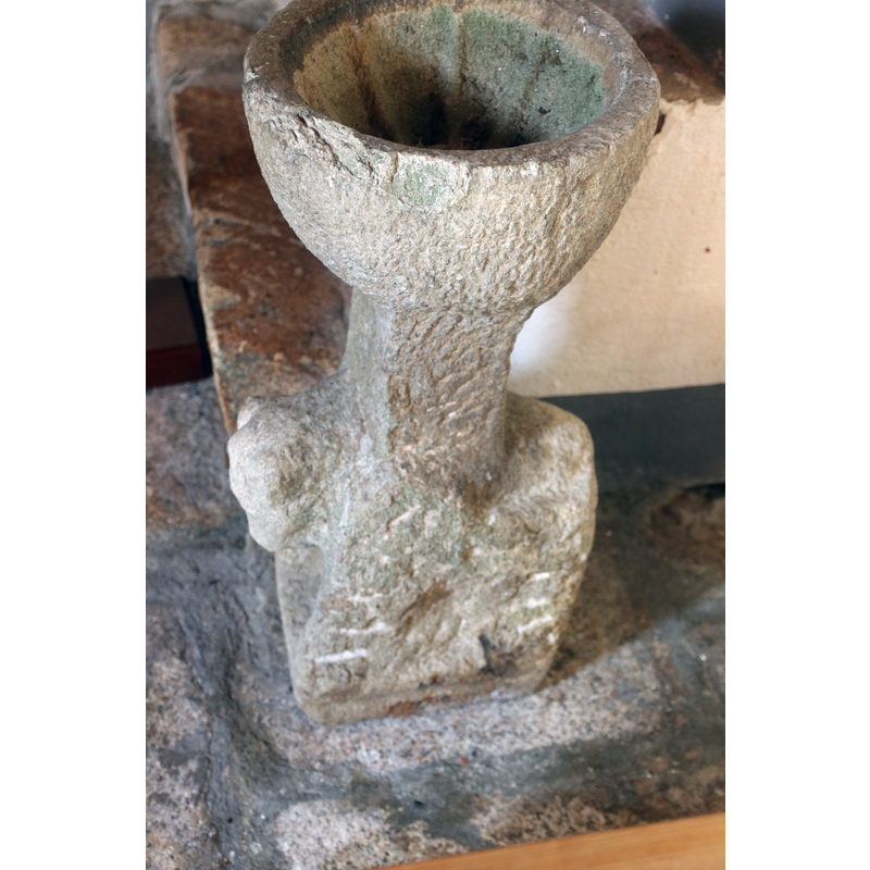 the stoup is located at the bottom of the steps leading up to the gallery