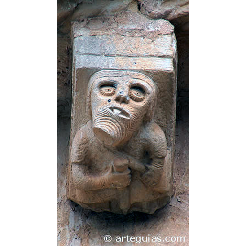 Source caption: "La iglesia románica de los Santos Justo y Pastor de Incinillas conserva básicamente su pequeño ábside semicircular de sillería con anchas columnas adosadas. Nos llama la atención lo voluminoso de los capiteles de estas columnas junto a los canecillos figurados del alero. Estas tallas muestran mascarones con aves, águilas con sus presas, músicos, un tullido con bastón, etc. La talla de estas esculturas es ruda pero muestra una expresividad especial, sobre todo en los personajes, cuyos ojos se remarcan con incisiones radiales."