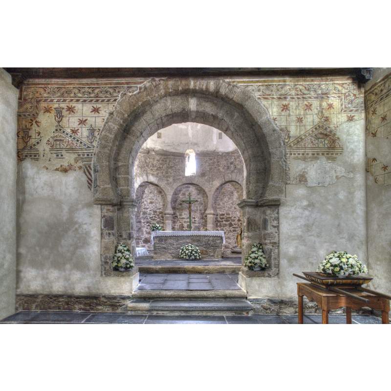 Source caption: "Es una iglesia mozárabe construida finales del siglo X o primeros del XI en Ponferrada, León. Tiene una únca nave rectangular (desde donde está hecha la foto) y un ábside ovalado al que se accede por un doble arco de herradura. El ábside se levanta sobre 9 arcos de herradura ciegos (en la imagen se ven tres). Las pinturas sobre los muros son del siglo XVIII."