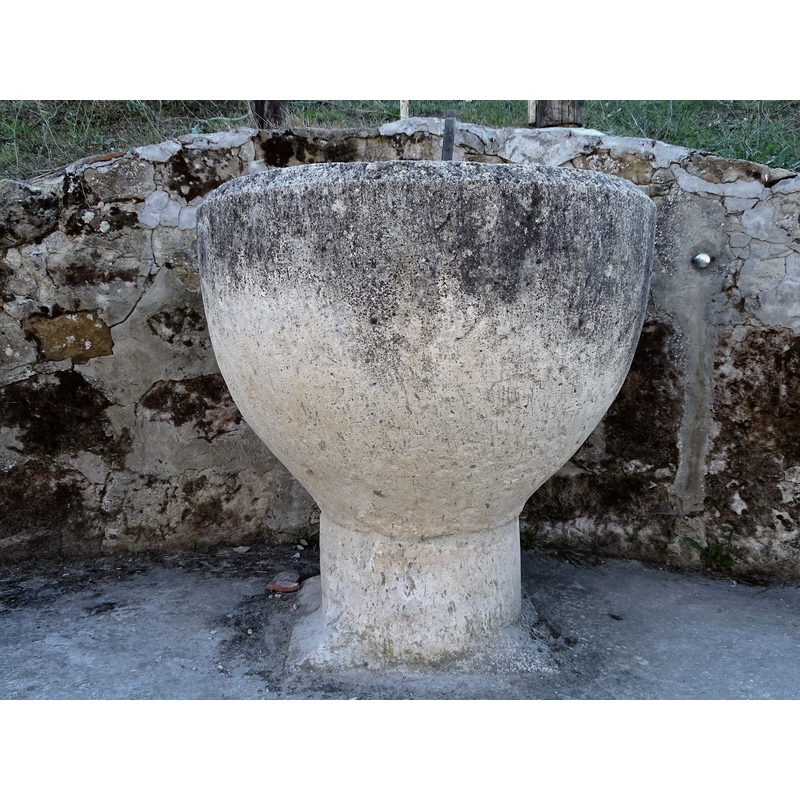 the former baptismal font from the abandoned village church now serves as water fountain