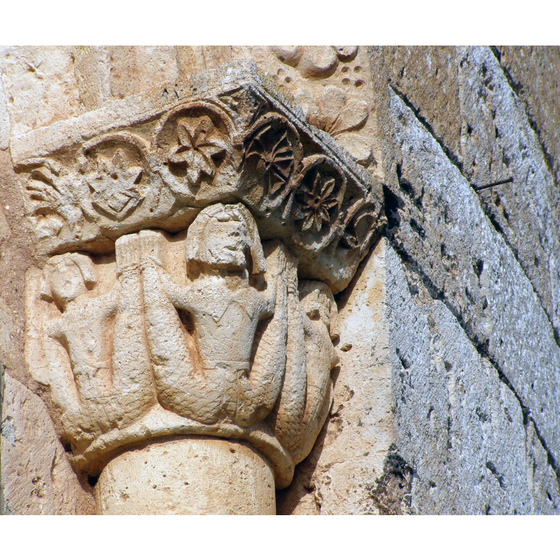 Source caption: "Capitel del ábside de la iglesia. Muestra tres sirenas con dos colas asidas por las manos."
