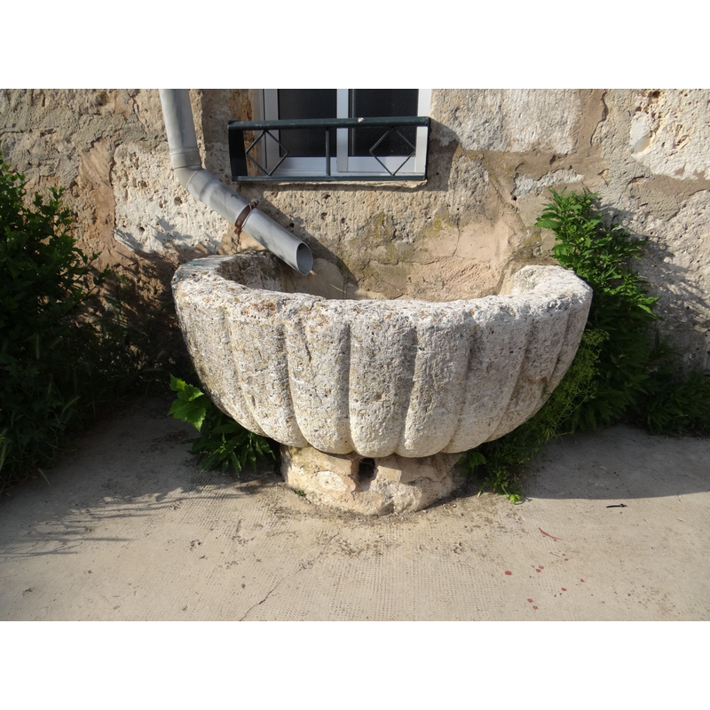 the former font in its present context, serving as raintrough in the village