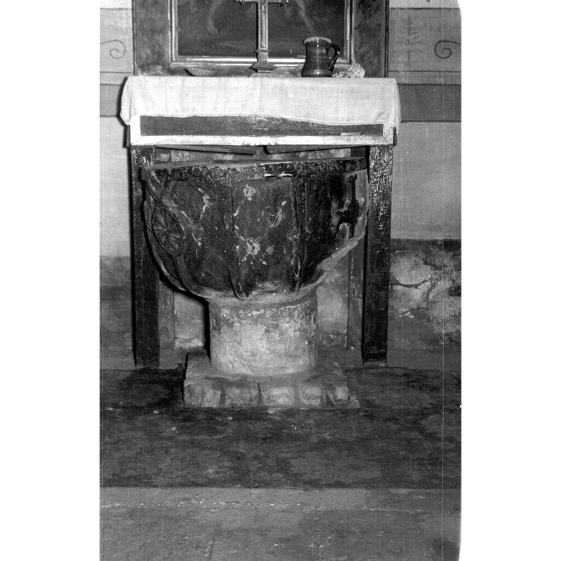 Source caption: "Vista frontal de la pila medieval; se decora con fuertes gallones que la abrazan y que terminan en motivos radiales biselados. En uno de los costados presenta una flor de lis en relieve"