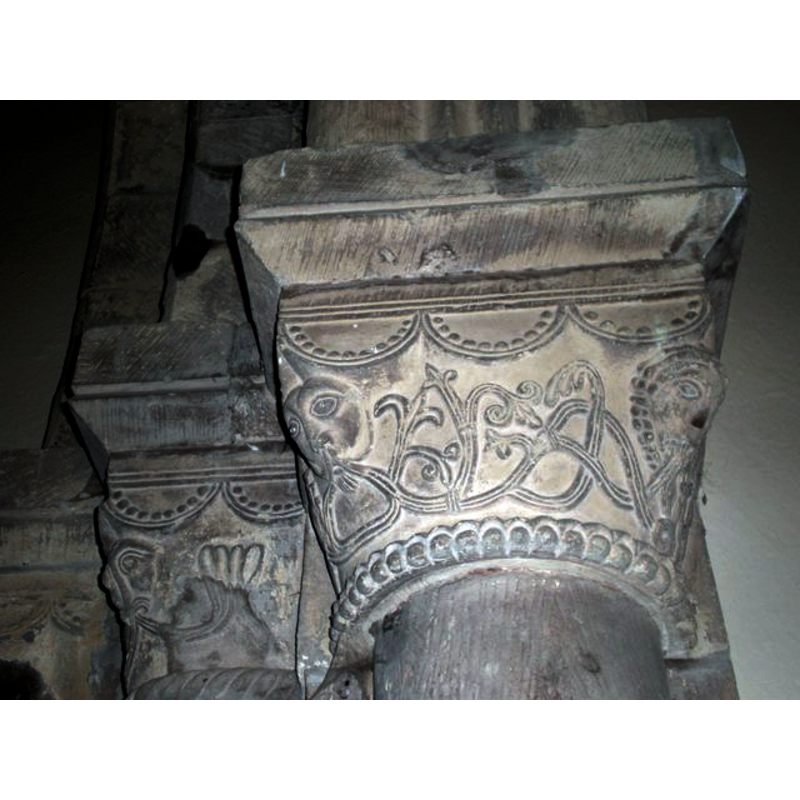 Source caption: "Detail of capitals, St. Ethelburga's church. Carved faces and tracery decorate the capitals of the columns supporting the Norman arch within the church."