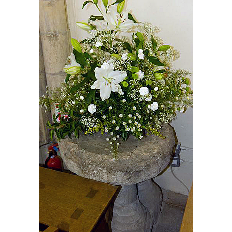 the remains of a medieval(?) font semi-hidden beside the lectern in the re-built church