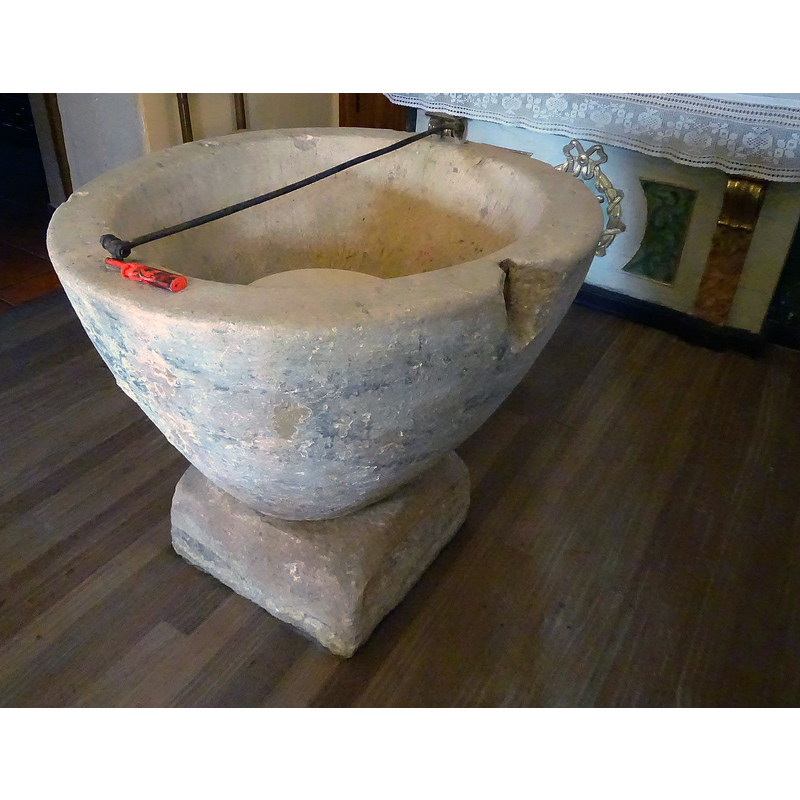 notice the damage to the upper rim caused by a metal staple splitting the stone -- the metal bar atop is the present locking hardware for the font cover