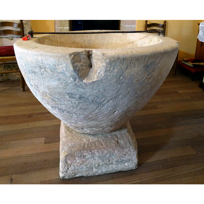 notice the damage to the upper rim caused by a metal staple splitting the stone -- the metal bar atop is the present locking hardware for the font cover
