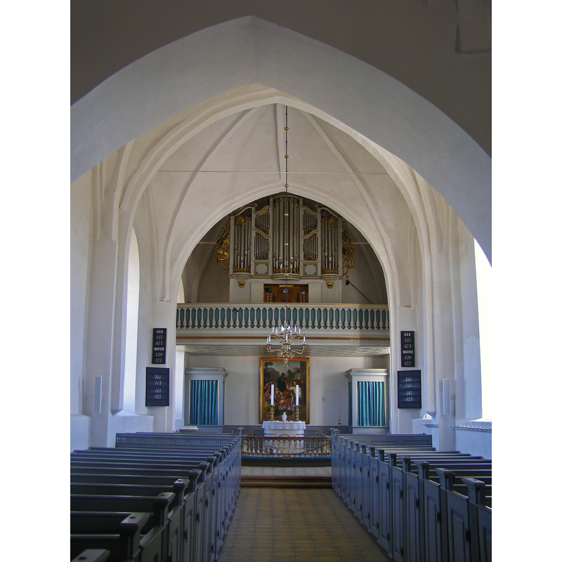 the top of the later font by Thorvaldsen is visible at the far end of the left side benches