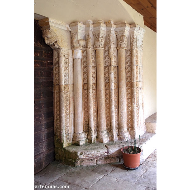 Source caption: "La iglesia de San Pedro de Aguillo conserva una amplia edificación gótica con cabecera poligonal. Del siglo XIII avanzado nos ha llegado una preciosa portada que tiene como lamentable "curiosidad" la de haber perdido las arquivoltas por la construcción del pórtico moderno. Sin embargo, ha sabido conservar una estupenda colección de capiteles figurados de gran interés. Contaba con numerosas arquivoltas apuntadas en cuya base queda una colección de columnas de distinto grosor en cuyos espacios intermedios se ubicaron puntas de diamante muy finas y desarrolladas. Los motivos esculpidos son variados y en distinto grado de conservación."