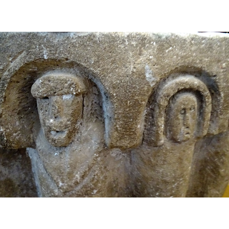this is the only figure that has a partial body, some sort of chain or priestly garment ribbon; both details suggest a central role of this person on the font programme