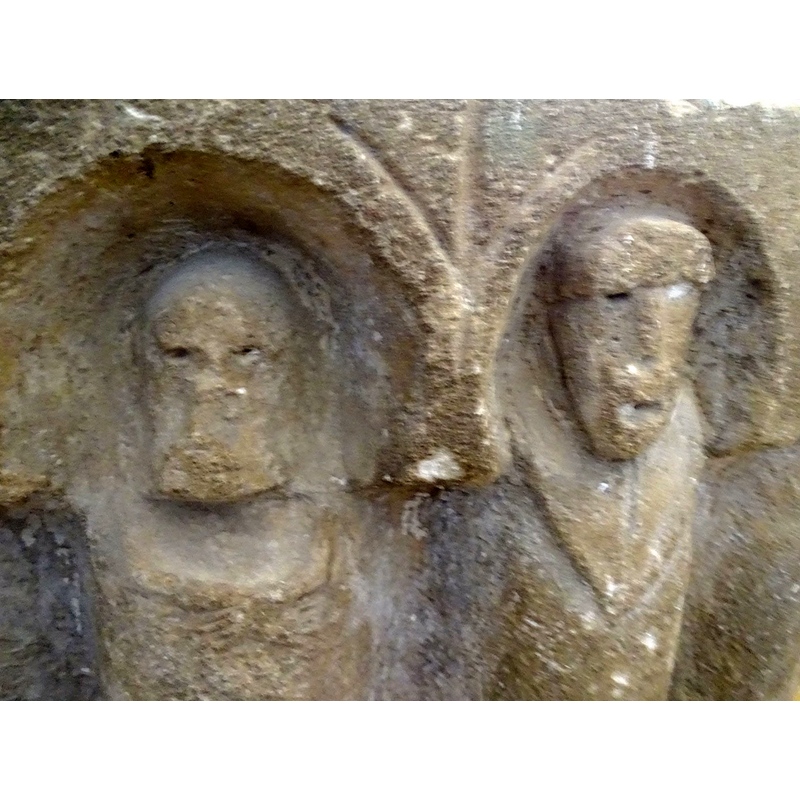 the upper area of the head and the damaged area of the lower face appear to indicate a bearded older male to the side of the central figure with the priestly garment