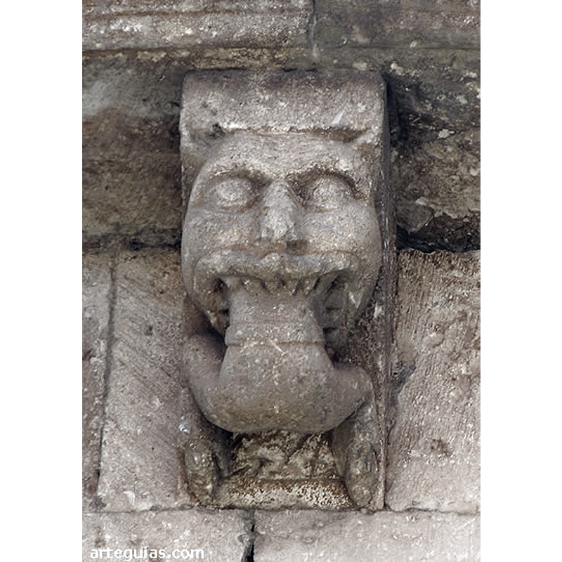 Source caption: "La colección de canecillos de esta iglesia de Arlanzón es muy original y expresiva, además de conservarse muy bien [...] un canecillo muy espectacular con la cabeza de lo que puede ser un león que engulle el cuerpo de un hombre del que sólo sobresale su mitad inferior."