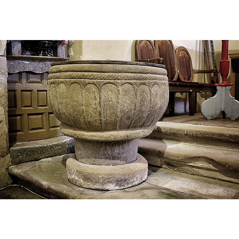 the font shows now standing on the north side steps of the chancel of the present church, obviously not the location it would have had in the old church