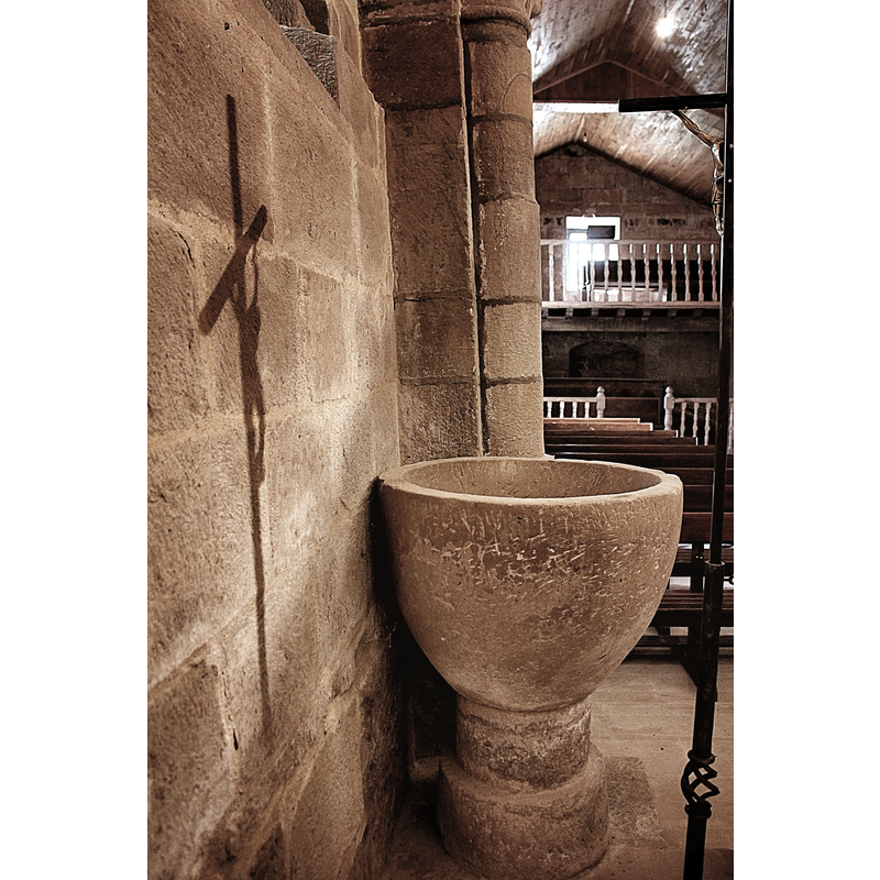 the medieval font seen here in its present [2020] location, behind the south pillar of the chancel