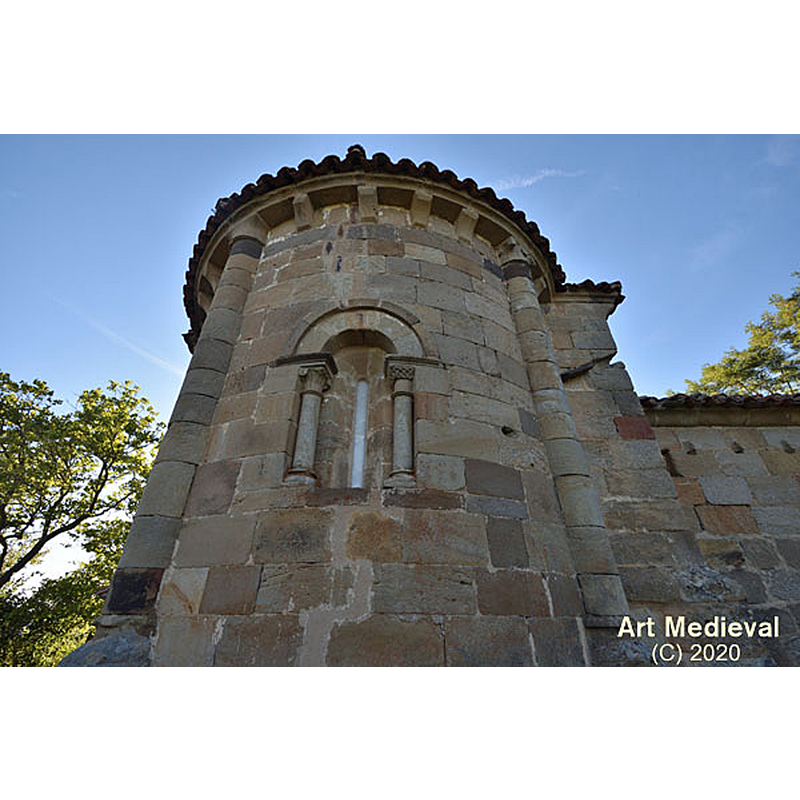 Source caption: " El ábside está dividido exteriormente en tres espacios gracias a dos columnas adosadas. El capitel de la columna situada más al sur es liso, mientras que el otro tiene decoración vegetal muy esquemática."