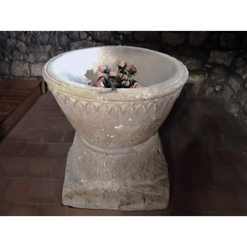 the font photographed ca. 2021 back in its original location at the west end, beneath the gallery, north side