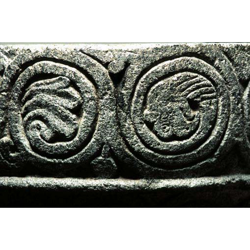 the spiral on the right of the image has been carved as the neck and head of an animal [cf. FontNotes]