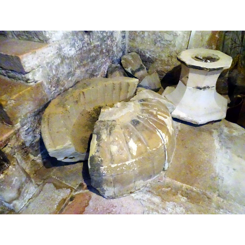 the broken up medieval basin; the pedestal base in the upper left corner of the image was its replacement base
