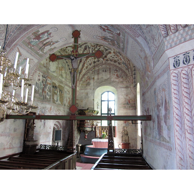 Source caption: "Kyrkorum i Alnö gamla kyrka" -- showing a modern font by the stairs leading up to the pulpit