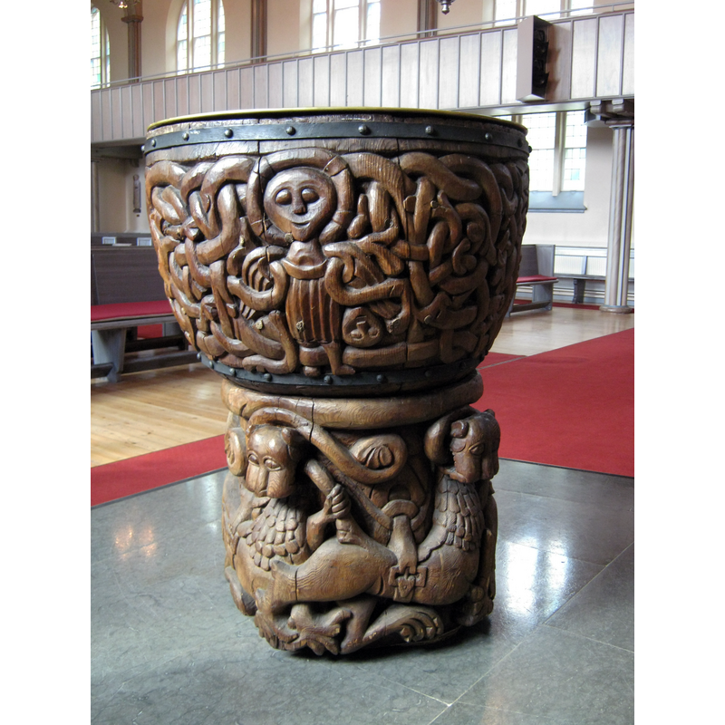 Source caption: "Døypefont i tre frå 1200-talet, i Alnö gamla kyrka, Sundsvall kommun, Västernorrland, Sverige"