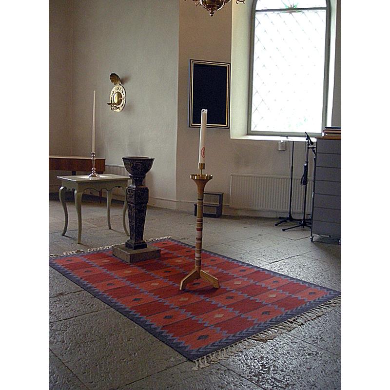 The present baptismal font was made of limestone in 1659, the maker said to be Michael Hacke, of Skänninge.