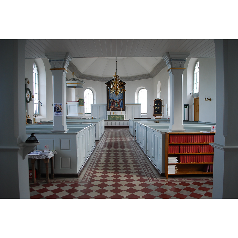 the medieval font, though invisible in this image, is located on the left [north] side, opposite the south entranceway, by the side altar decorated with a cross retable