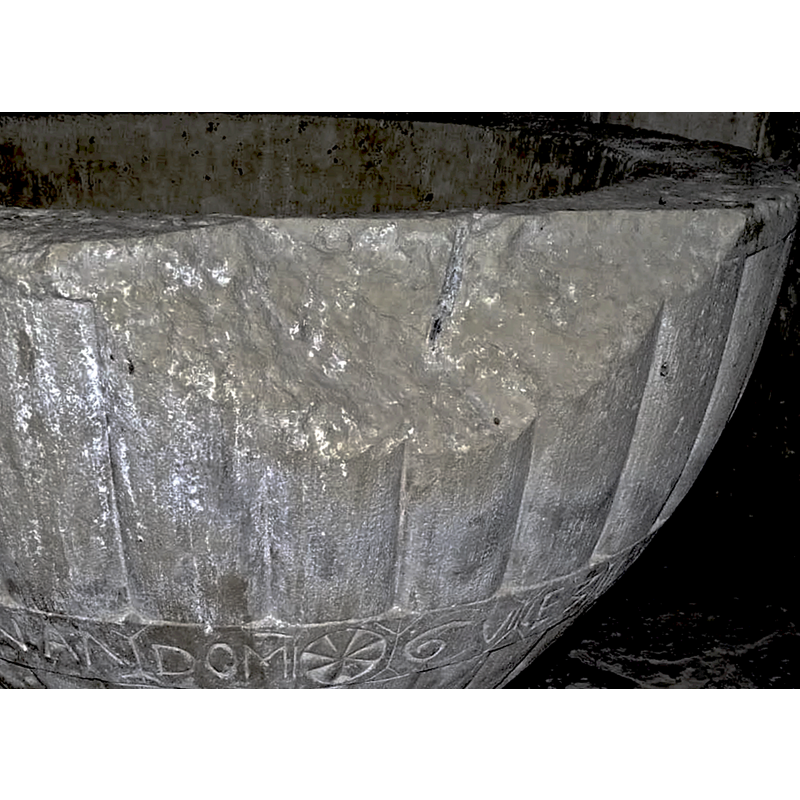 the large area of damage showing the drilled hole into which a metal peg was anchored; it would have probably been the different expansion ratio of metal vs. stone that caused the splitting of the stone