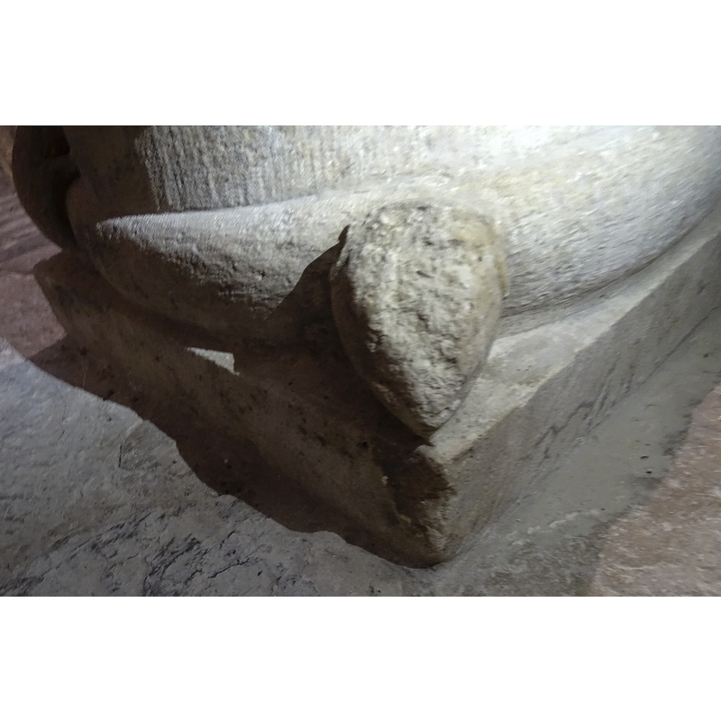 very damaged now; the roll moulding behind gets narrower at the left because it is the taild of the body of the snake that circles the lower base