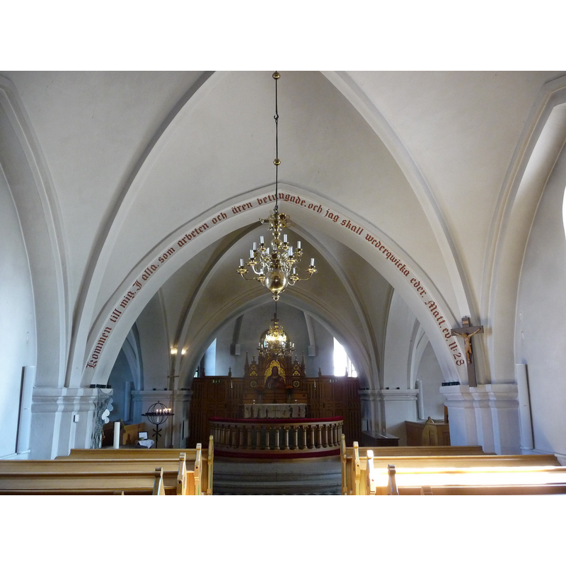 the large white Paschal candle visible at the far [east] end of the left [north] bank of benches marks the location of the font