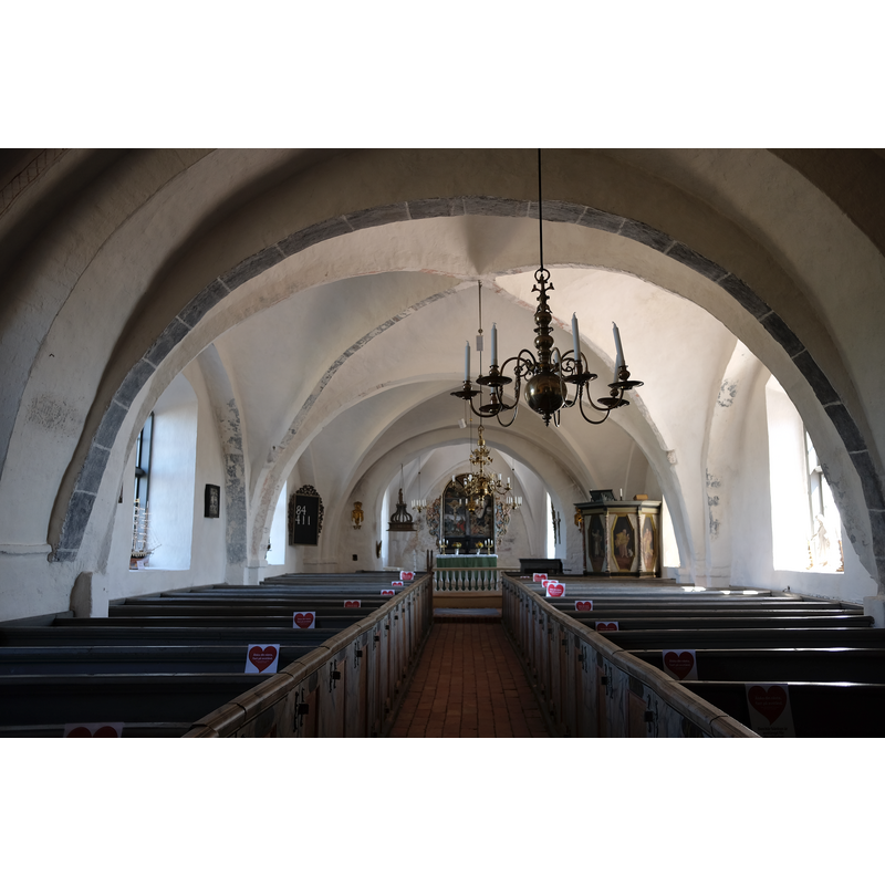 Source caption: "Sankt Ibbs gamla kyrka, Ven." -- the wooden cover hanging from the ceiling at the far end, left side, marks the location of the baptismal font