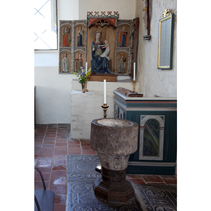 Source caption: "Saint Olofs church in Simrishamn, Sweden." -- showing the medieval font in front of the Madonna and Child altar