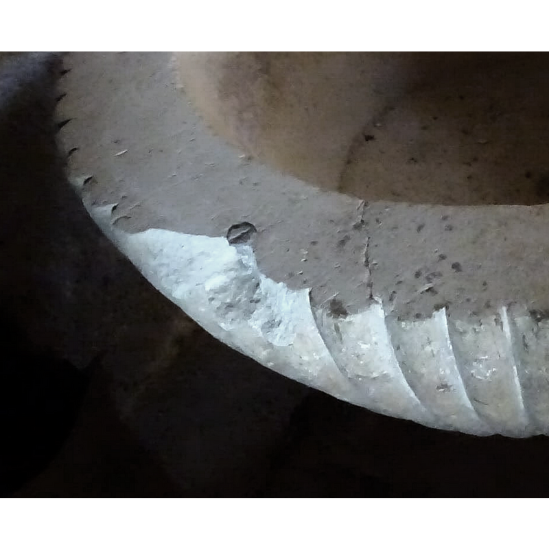 a metal plug for the anchoring of the cover and the damage caused to the upper rim; there is similar damage also at the opposite side of the basin