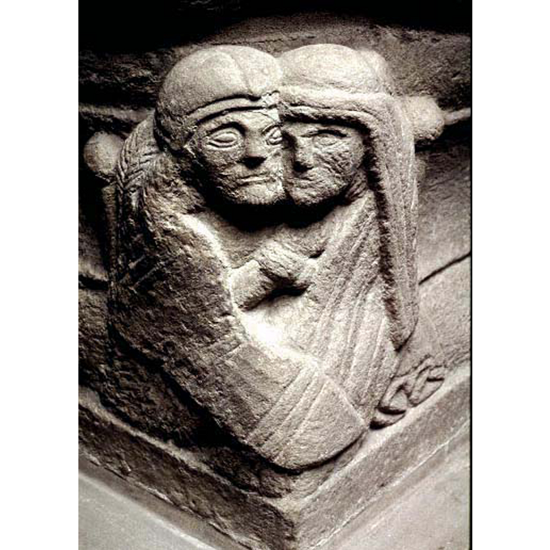man with long braided hair on the left; woman with long hair on the right; embracing and wrapped in their cloaks or mantles